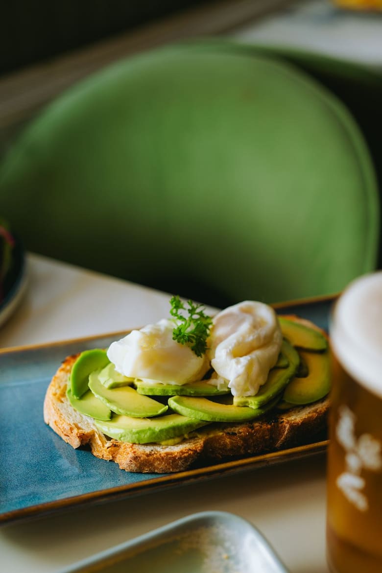 A lunch plate with poached egg, avocado and greens